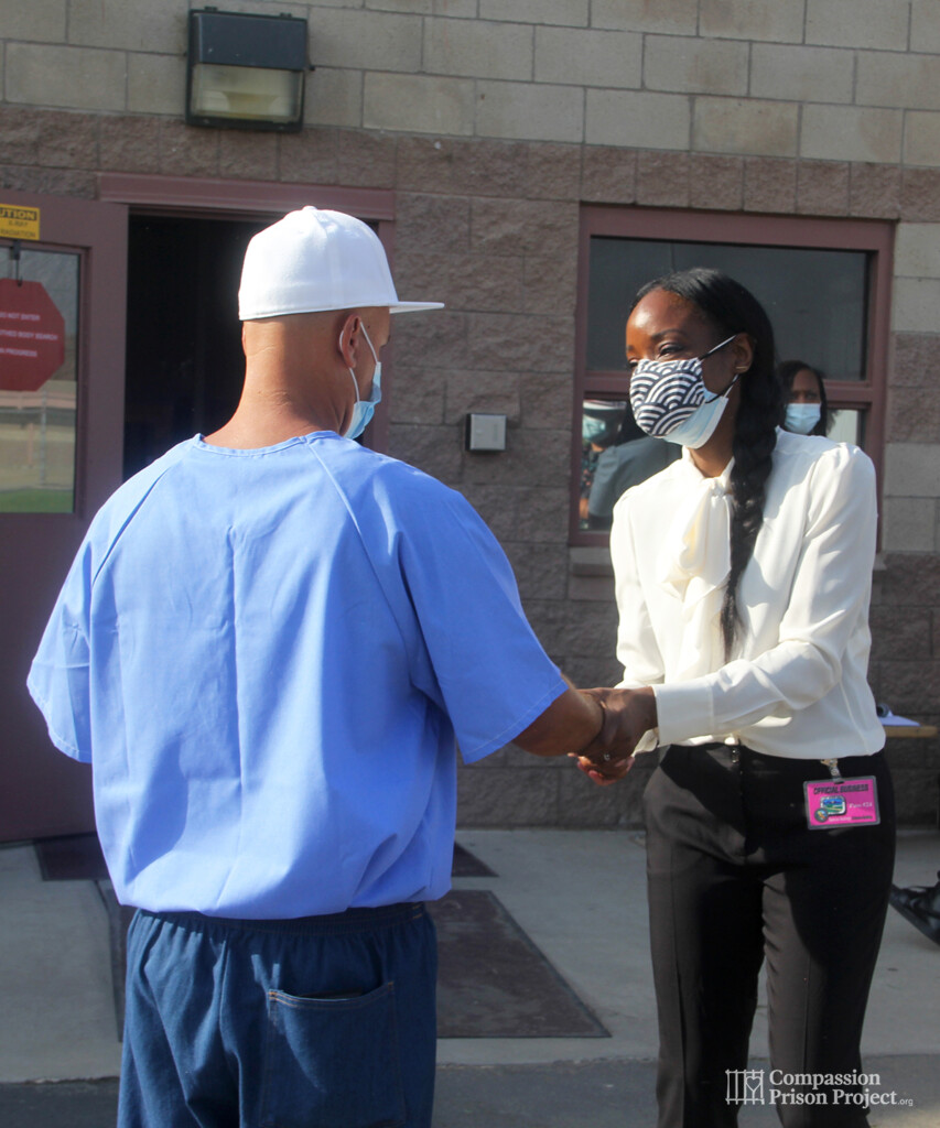 Nadine Burke Harris shaking hand of young man in prison