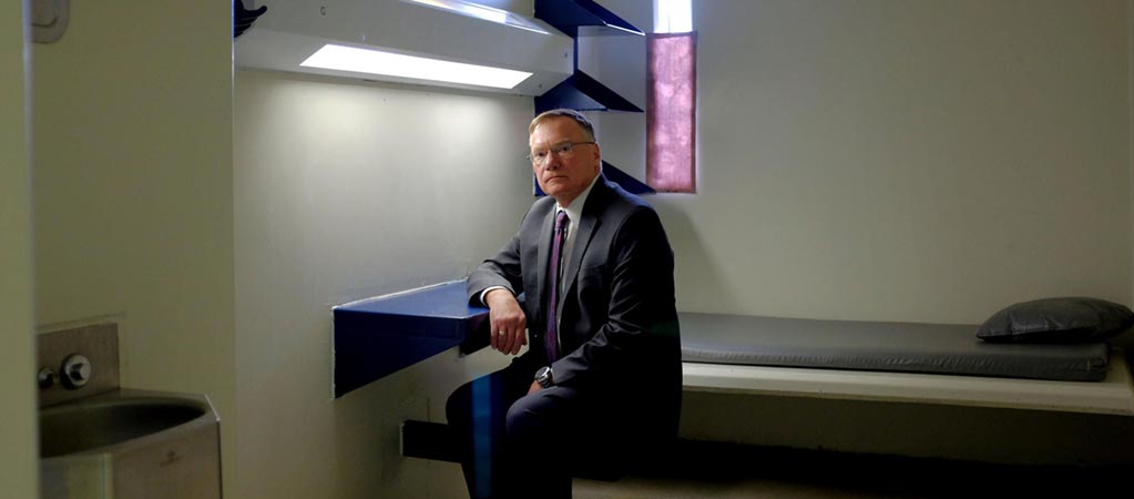 Rick Raemisch sitting in a solitary confinement cell